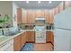 Bright kitchen featuring wooden cabinets, white appliances and countertops, and ample natural light at 949 E Estates Blvd # 303, Charleston, SC 29414