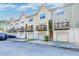 View of a row of townhomes each with a garage and outdoor patio in a suburban area at 949 E Estates Blvd # 303, Charleston, SC 29414