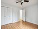 Bright bedroom features wood-look floors, neutral walls, a ceiling fan, and double-door closet at 112 Chownings Ln, Goose Creek, SC 29445