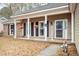 Charming front porch with white columns, black shutters, and hanging flower baskets, adding to the home's curb appeal at 112 Chownings Ln, Goose Creek, SC 29445