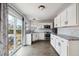 Kitchen featuring stainless steel appliances, white cabinetry, granite counters, updated backsplash, wood-look floors, and sliding glass doors at 112 Chownings Ln, Goose Creek, SC 29445