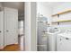 Bright laundry room with washer and dryer and wooden shelves at 112 Chownings Ln, Goose Creek, SC 29445