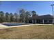 Outdoor community pool with a dark cover on it, surrounded by lawn and a building at 112 Chownings Ln, Goose Creek, SC 29445
