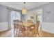 Dining room featuring hardwood floors, large window, stylish light fixture, and easy access to living room at 1137 Windsome Pl, Mount Pleasant, SC 29464