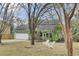 Charming home with a well-maintained yard, garage, mature trees, and white Adirondack chairs at 1137 Windsome Pl, Mount Pleasant, SC 29464