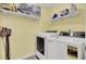 Functional laundry room equipped with a washer, dryer, overhead storage, and pale yellow paint at 1137 Windsome Pl, Mount Pleasant, SC 29464