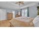 Spacious bedroom featuring tray ceiling, wood floors, and a window with blue curtains at 1137 Windsome Pl, Mount Pleasant, SC 29464