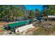 A high angle view of poultry houses, animal pens, and other farm buildings nestled among mature trees at 120 Rancho Hippey Way, Saint George, SC 29477