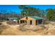 An aerial view of a barn with a green roof and a fenced corral area on a sunny day at 120 Rancho Hippey Way, Saint George, SC 29477