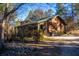 Charming log cabin with a green metal roof and inviting front porch, surrounded by mature trees and natural landscaping at 120 Rancho Hippey Way, Saint George, SC 29477