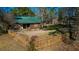 Charming exterior view of a log cabin featuring a green metal roof and fenced front yard at 120 Rancho Hippey Way, Saint George, SC 29477