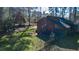 Back exterior view of the log cabin with a small porch and shaded lawn at 120 Rancho Hippey Way, Saint George, SC 29477