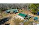 Aerial view of a farm with multiple buildings, paddocks, farm equipment, and lake nearby at 120 Rancho Hippey Way, Saint George, SC 29477