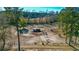 Aerial view of a horse farm with horses grazing, paddocks, and mature trees on a clear day at 120 Rancho Hippey Way, Saint George, SC 29477