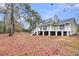View of home's back exterior with a large deck and lush backyard. Great for outdoor entertaining! at 1545 Sterling Oaks Dr, Moncks Corner, SC 29461