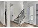 Bright foyer with a gray carpeted staircase and white risers and railings at 1545 Sterling Oaks Dr, Moncks Corner, SC 29461