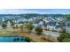 Aerial view features a pond surrounded by a neighborhood with colorful houses; waterfront real estate at 1608 Fetterbush Ln, Johns Island, SC 29455