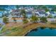 Scenic aerial view showcasing a community of homes with pond, palm trees, and lush greenery at 1608 Fetterbush Ln, Johns Island, SC 29455