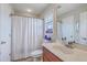 Bright bathroom featuring a vanity with sink, mirror, and shower with a striped curtain at 1608 Fetterbush Ln, Johns Island, SC 29455