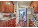 Galley kitchen with wooden cabinets, granite countertops, and stainless steel refrigerator, leading to the dining room at 1608 Fetterbush Ln, Johns Island, SC 29455