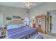 Bright main bedroom with a ceiling fan, patterned bedspread, decor art on walls, and ensuite bathroom access at 1608 Fetterbush Ln, Johns Island, SC 29455