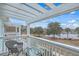 Peaceful view of the pond from a cozy balcony with white pergola, railing, chair and table at 1608 Fetterbush Ln, Johns Island, SC 29455