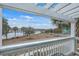 Scenic view of a peaceful pond from a cozy balcony with white pergola and railing at 1608 Fetterbush Ln, Johns Island, SC 29455