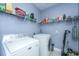Well-lit laundry room with modern, full-size washer and dryer and lots of shelving for storage at 206 President Cir, Summerville, SC 29483
