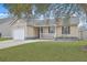 Charming single-story home with a well-manicured lawn, attached garage, and inviting front porch at 209 Persimmon Cir, Goose Creek, SC 29445