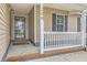 Inviting front porch with white railings, brick trim, and glass door at 209 Persimmon Cir, Goose Creek, SC 29445