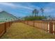 Wide backyard area with wood privacy fence, freshly laid grass, and homes in the distance at 219 Corvus St, Summerville, SC 29483