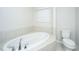 Elegant bathroom featuring a luxurious soaking tub and toilet with a bright window at 219 Corvus St, Summerville, SC 29483