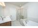 Elegant bathroom featuring a large vanity, a walk-in shower with glass door and a soaking tub at 219 Corvus St, Summerville, SC 29483