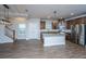 Modern eat-in kitchen with stainless steel appliances, island with pendant lights, and staircase in view at 219 Corvus St, Summerville, SC 29483
