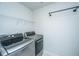 Well-lit laundry room featuring modern washer and dryer units with a rack and shelf for storage at 219 Corvus St, Summerville, SC 29483
