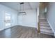 Bright living room with wood floors, modern lighting, and a staircase leading to the upper floor at 219 Corvus St, Summerville, SC 29483