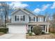 Charming two-story home featuring blue siding, black shutters, well-manicured landscaping, and a two-car garage at 223 Chipping Sparrow Drive Dr, Summerville, SC 29485