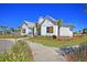 A charming clubhouse with palm trees and manicured landscaping enhances community appeal at 295 Calm Water Way, Summerville, SC 29486