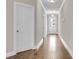 Bright hallway with hardwood floors and white trim leads to the front door at 295 Calm Water Way, Summerville, SC 29486