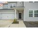 A well-kept gray home with a front yard, a garage door, a front door, and bushes at 296 Firewheel Ct, Summerville, SC 29486