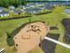 Aerial view of a community playground with swings, slides, and surrounding green space at 296 Firewheel Ct, Summerville, SC 29486