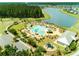 Aerial view of community pool with lounging areas, playground, and scenic lake backdrop at 296 Firewheel Ct, Summerville, SC 29486