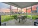 View of the screened porch with a table set, and the large grassy backyard at 296 Firewheel Ct, Summerville, SC 29486