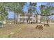 Lush backyard with mature trees, featuring a stone pathway and outdoor picnic tables at 301 E Richardson Ave, Summerville, SC 29483