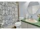 Functional bathroom with a blue patterned shower curtain and green countertop at 301 E Richardson Ave, Summerville, SC 29483