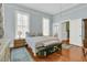 Sunlit bedroom with wood floors, bench, and large windows, offering a peaceful and relaxing atmosphere at 301 E Richardson Ave, Summerville, SC 29483