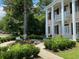 Two-story home featuring white columns and flower gardens adding color and charm to the property's exterior at 301 E Richardson Ave, Summerville, SC 29483
