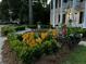 A beautiful hanging basket and colorful flower beds with decorative planters enhance this home's curb appeal at 301 E Richardson Ave, Summerville, SC 29483