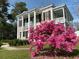 Charming two-story home with classic white columns and a beautiful pink azalea bush in the front yard at 301 E Richardson Ave, Summerville, SC 29483