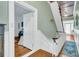 Bright hallway with hardwood floors, stairs, and an open bedroom doorway at 301 E Richardson Ave, Summerville, SC 29483